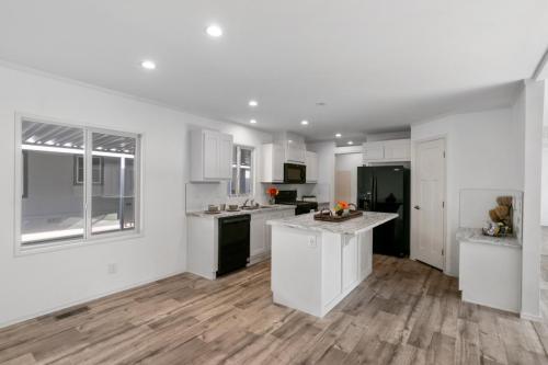 A white kitchen with wood floors and white walls.