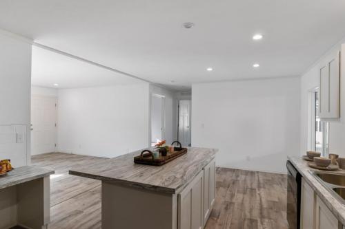 An empty kitchen with wood floors and white walls.