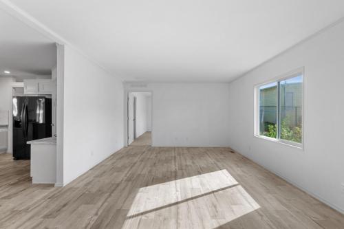 An empty room with wood floors and a window.