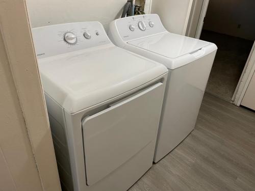 Two washers and dryers in a small room.
